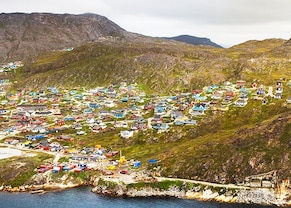 view of the city of qaqortoq nestled among the mountains