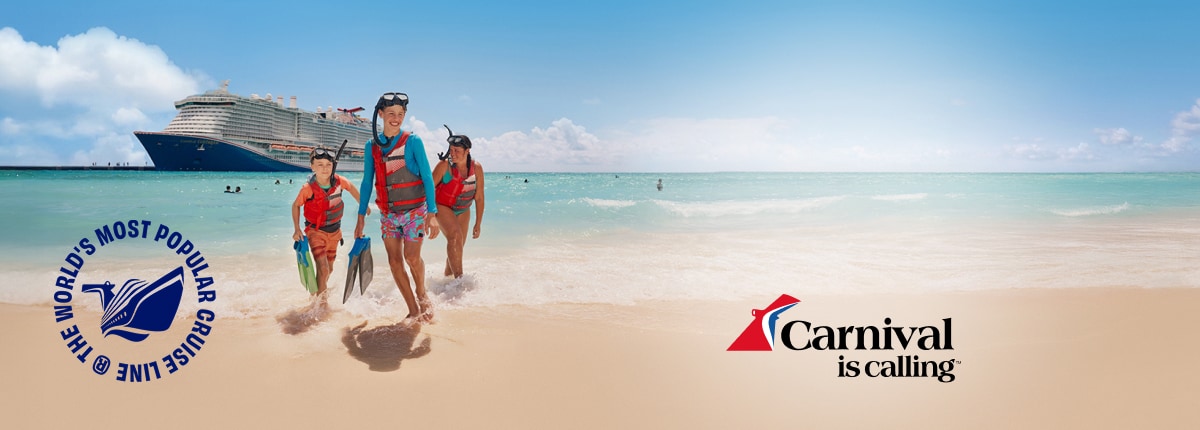 guests in snorkeling gear and life jackets walking from the ocean onto a sandy beach with a carnival cruise ship in the background.