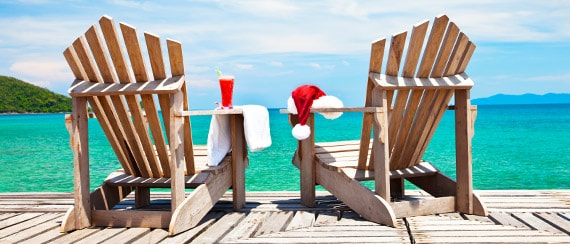 a pair of chairs on a dock overlooking the water