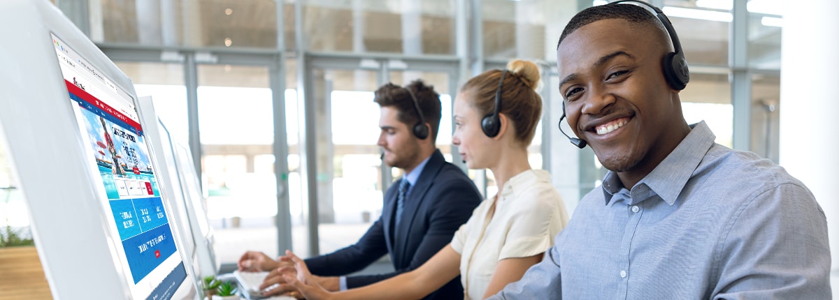 personal vacation planners wearing headsets sitting in front of computers in an office setting