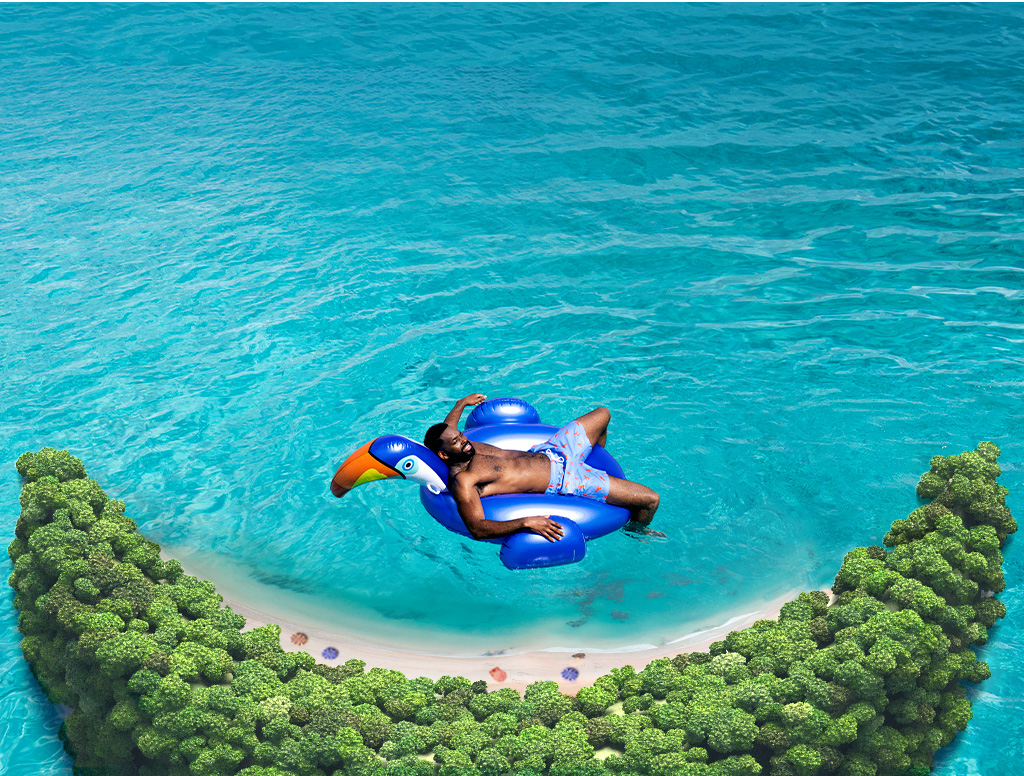 aerial view of half moon cay and a man floating on a tucan float