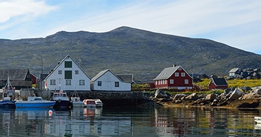 colorful houses and boats on a lake in nanortalik, greenland