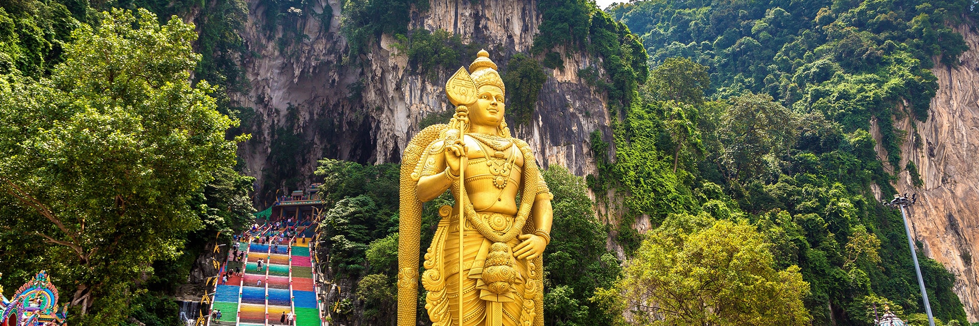 view of a statue in front of the entrance to the batu cave in port klang