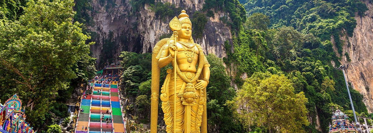 view of a statue in front of the entrance to the batu cave in port klang