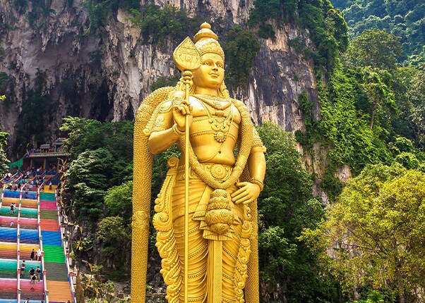 view of a statue in front of the entrance to the batu cave in port klang
