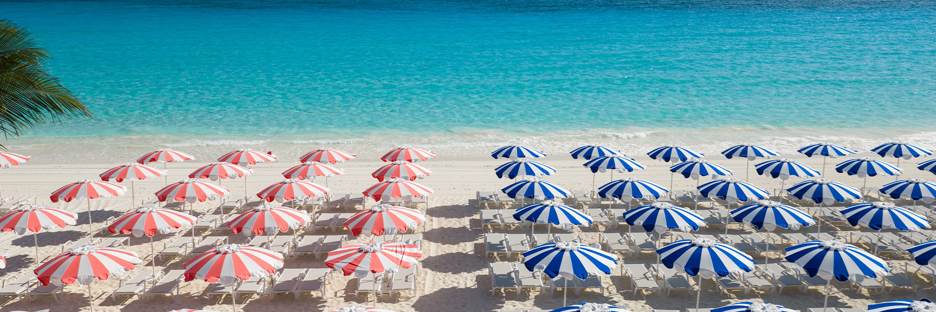 red and blue umbrellas at a beach at relaxaway half moon cay