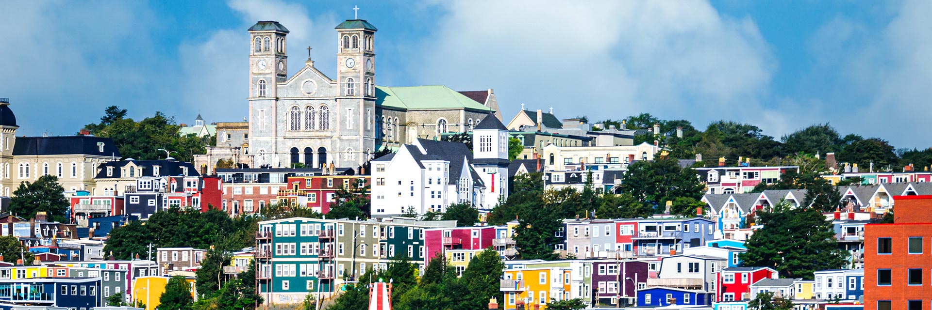view of the basilica of st john the baptist and the colorful buildings in st john's newfoundland