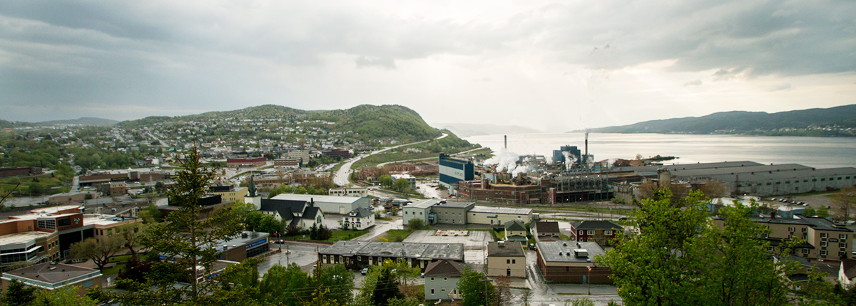 the corner brook village with mountains in the background