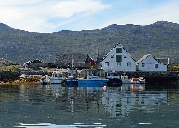 colorful houses and boats on a lake in nanortalik, greenland