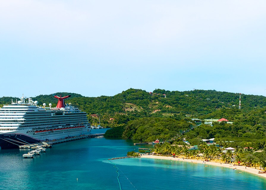 a carnival ship docked at an island