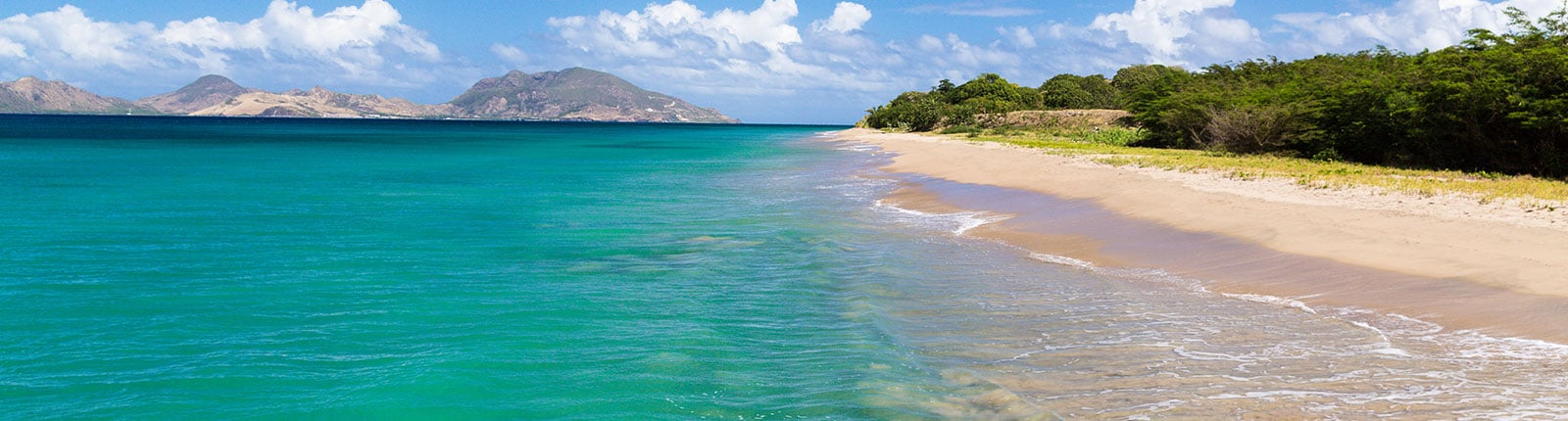 View of the gentle waves lapping an isolated beach in St. Kitts