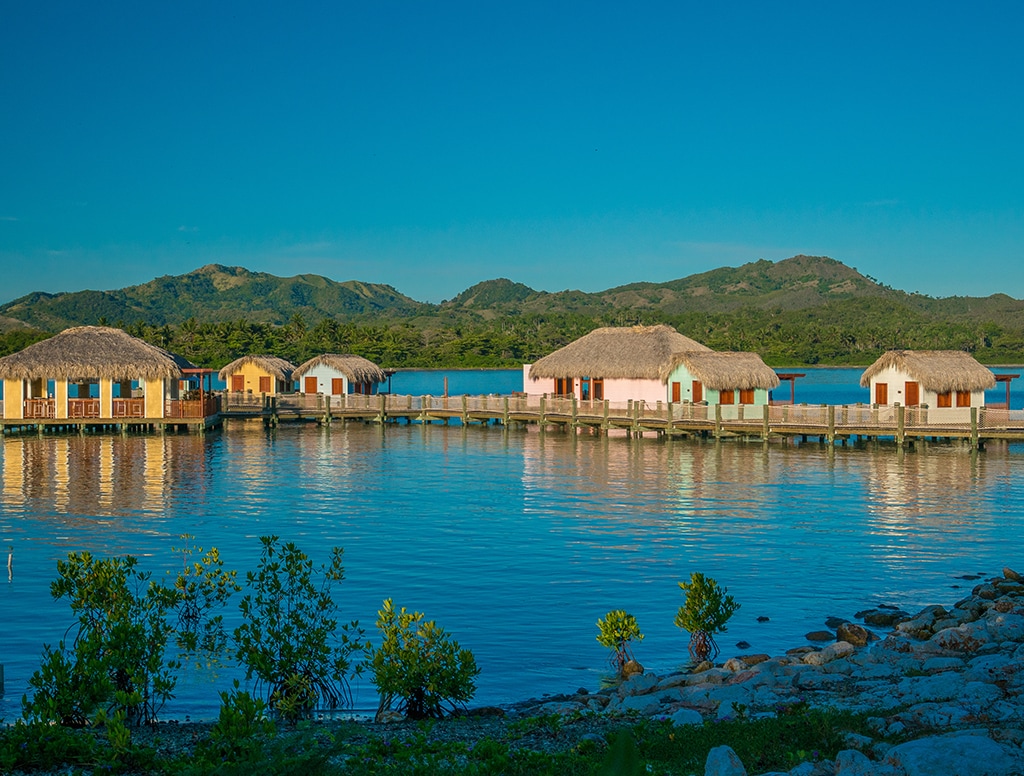 scenic view of tiki huts on the water in Amber Cove. 