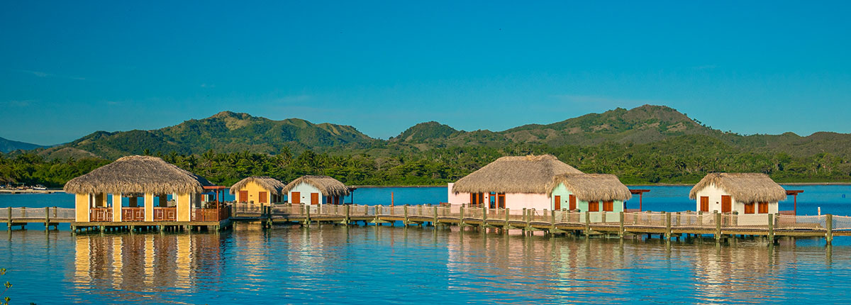 scenic view of tiki huts on the water in Amber Cove. 