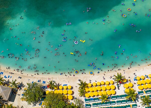 an aerial view of guests swimming off the coast of the beach