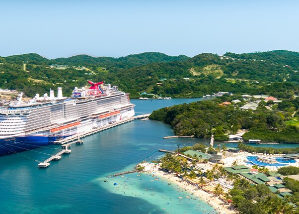 a carnival ship docked at isla tropicale