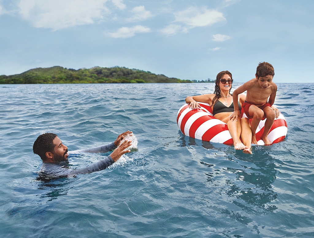 a family of three swims in the sea