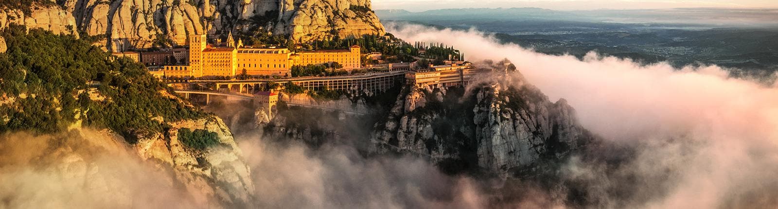 Santa Maria de Montserrat jutting out of the clouds in Barcelona, Spain