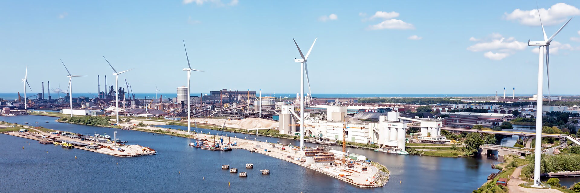 aerial view of windmills outside of a industrial harbor in ijmuiden