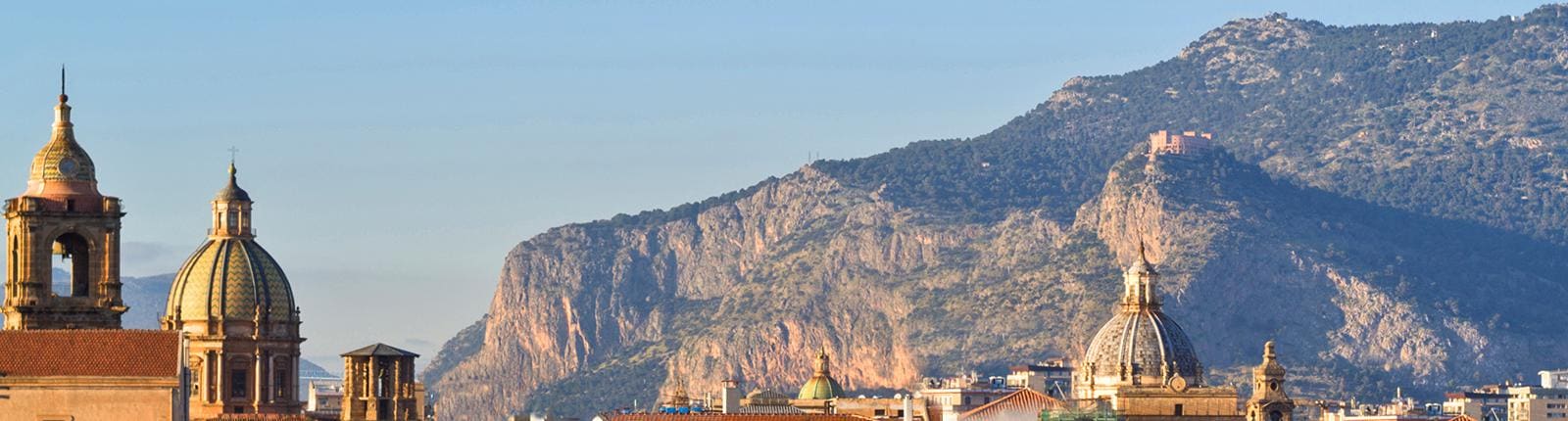 Looking through the architectural domes to the hillsides of Palermo, Italy