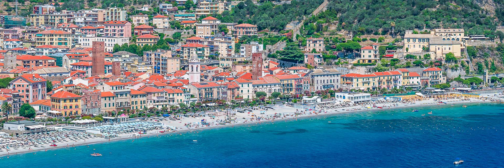 coastline and town in savona with mountains in the background