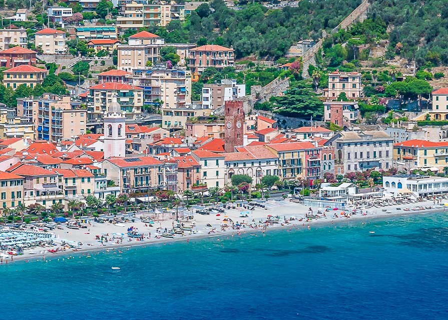 coastline and town in savona with mountains in the background