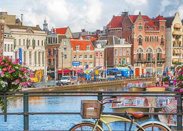 bicycles on a bridge over a canal with colorful buildings