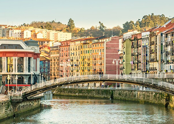 the ria del bilbao running through the city surrounded by colorful buildings