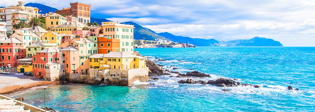 view of blue ocean and colorful city buildings in genoa italy