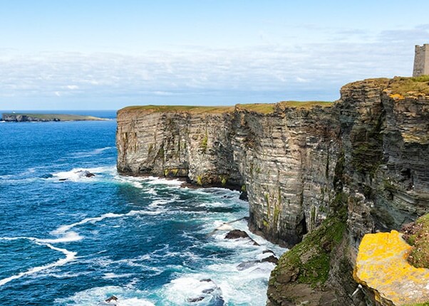 fort overlooking blue waters and large cliffs in kirkwall, orkney islands, scotland