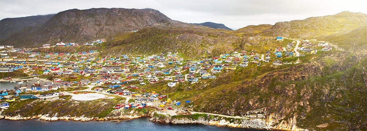 view of the city of qaqortoq nestled among the mountains