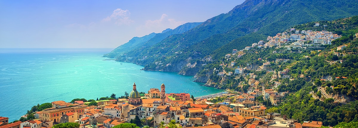 view of the Italian coastline and city with turquoise waters and lush mountains