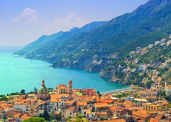 view of the Italian coastline and city with turquoise waters and lush mountains
