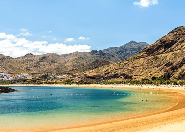 guests relax on the beach surrounded by mountains
