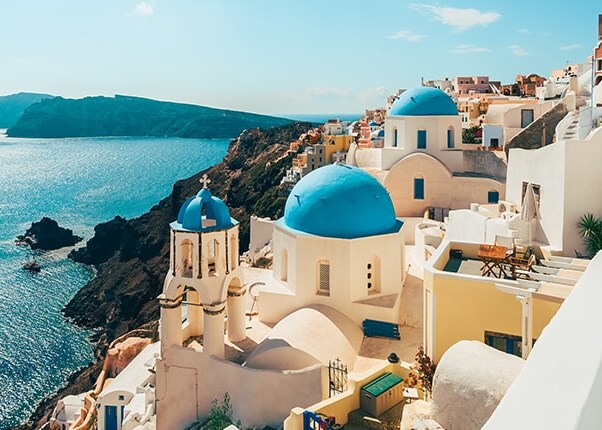white buildings along the teal coastline of santorini, greece