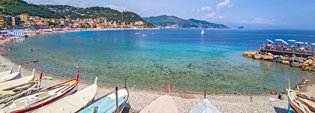 blue ocean water and boats on the shore of savona