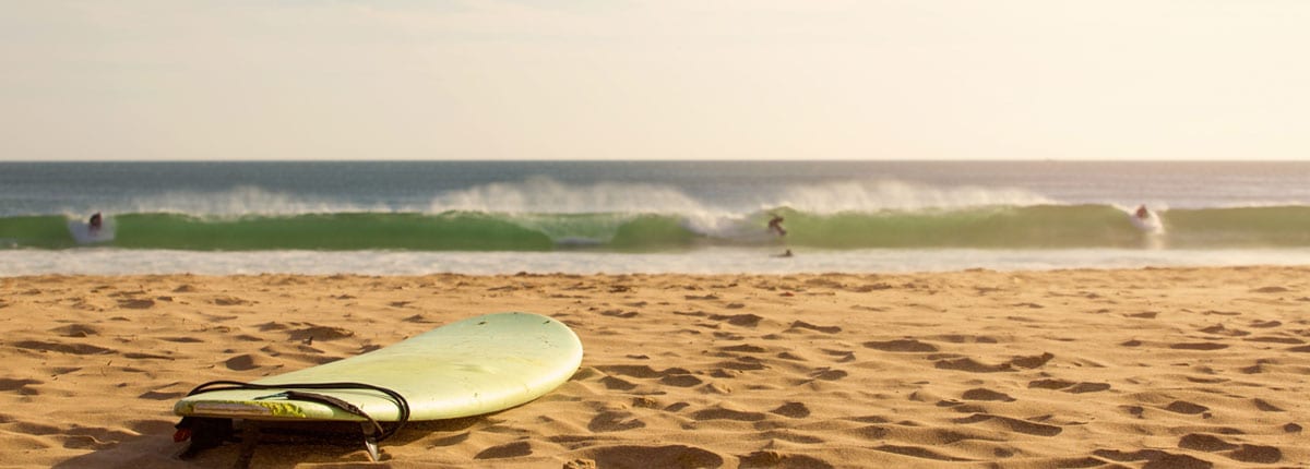 a surf board on the sand in cocoa beach