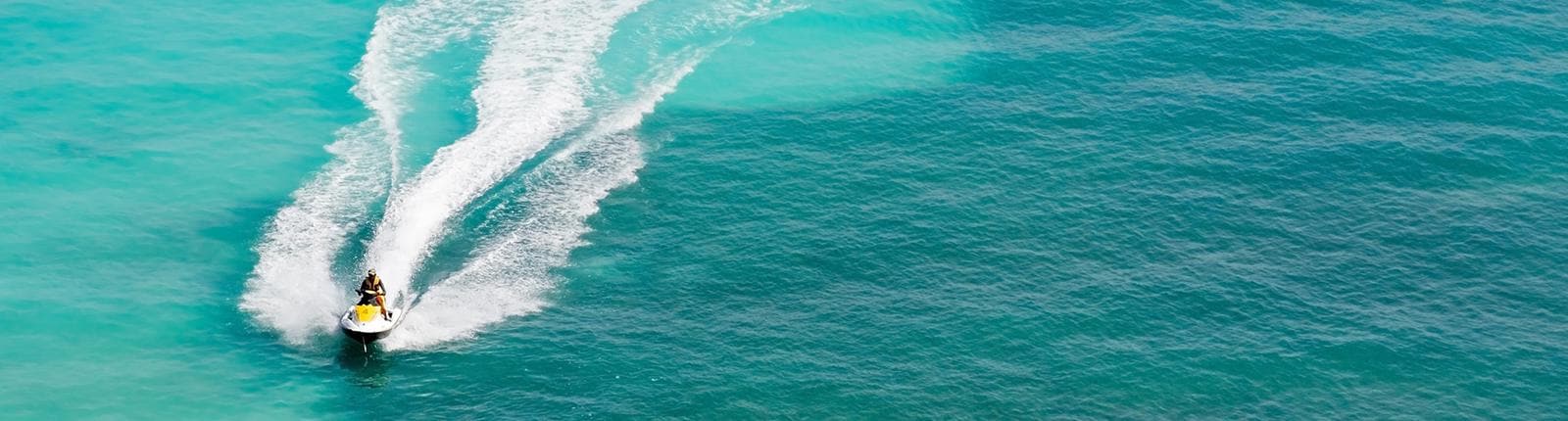 Jetski gliding through a light blue body of water in Zihuanatejo, Mexico