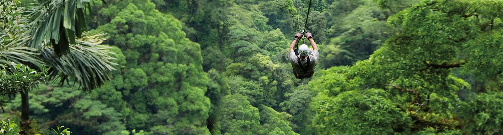 Man ziplining through a beautiful green forrest in Puntarenas, Costa Rica
