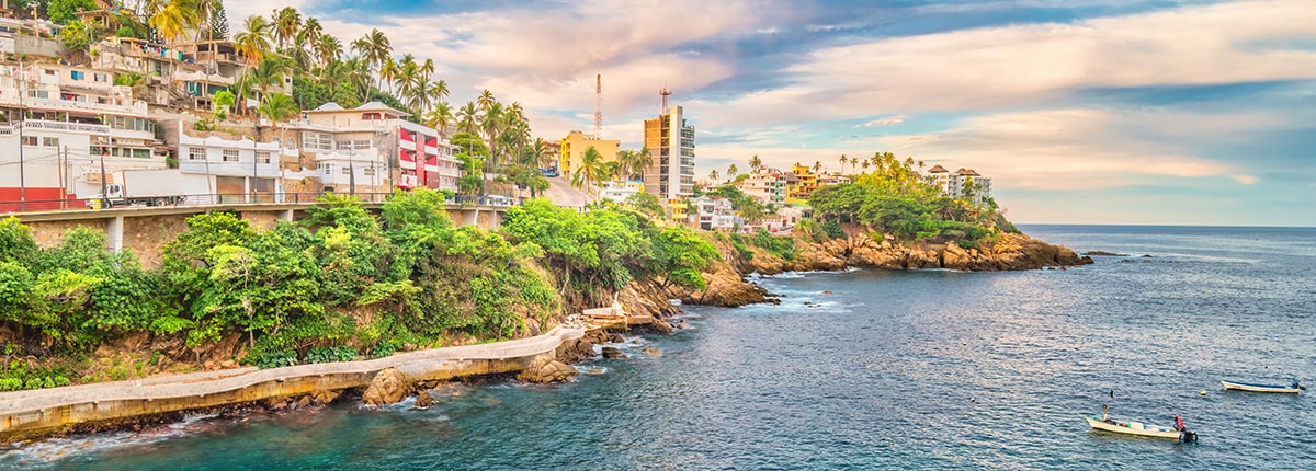 small boats in acapulco guerrero mexico on a sunny day next to the coastline