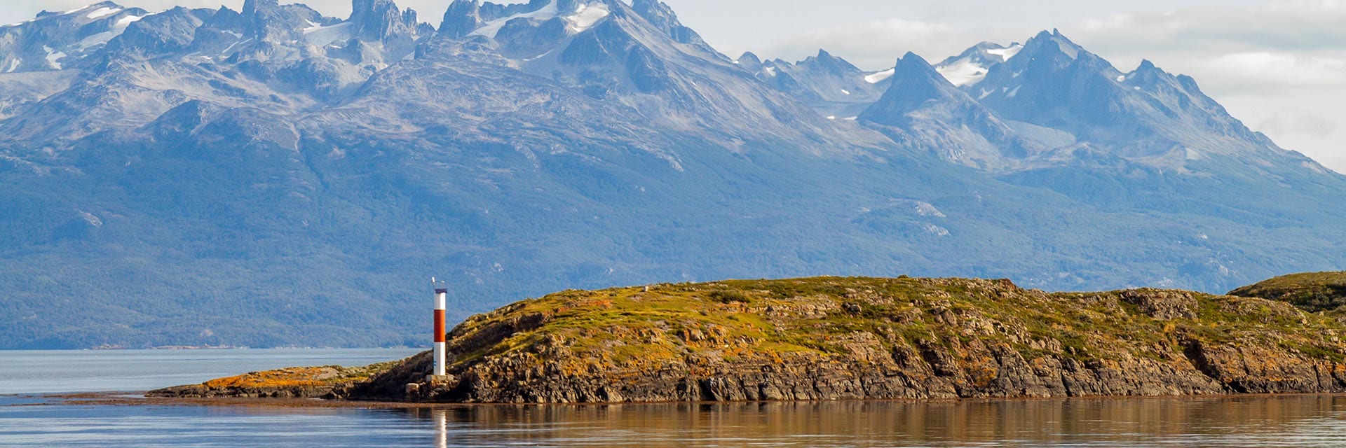 view of the mountains and a lighthouse along the water from the beagle channel