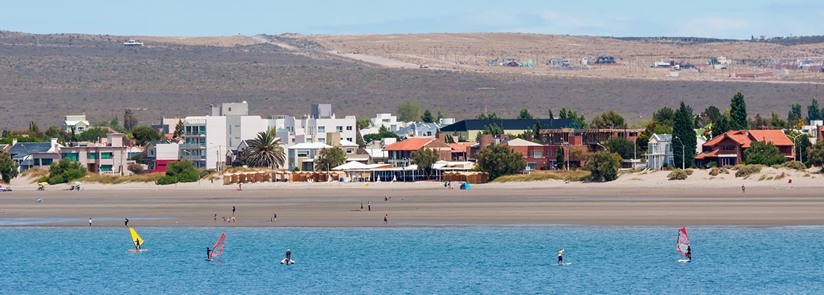the bright coastline and windsurfers enjoying the waters in puerto madryn