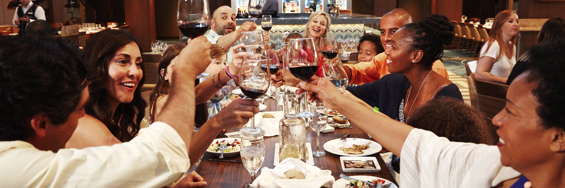 guest toasting with their wine glasses in the dinning room onboard a carnival cruise