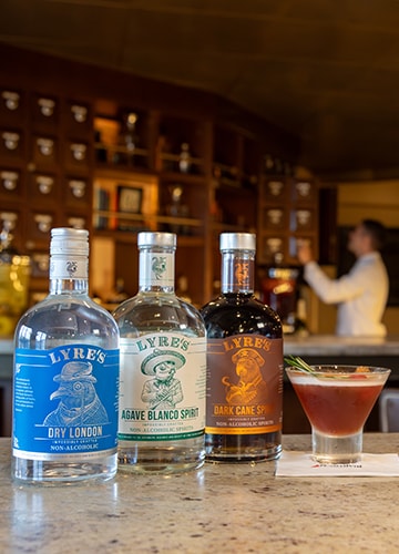 three bottles of lyre's non-alcoholic drinks lining the alchemy bar