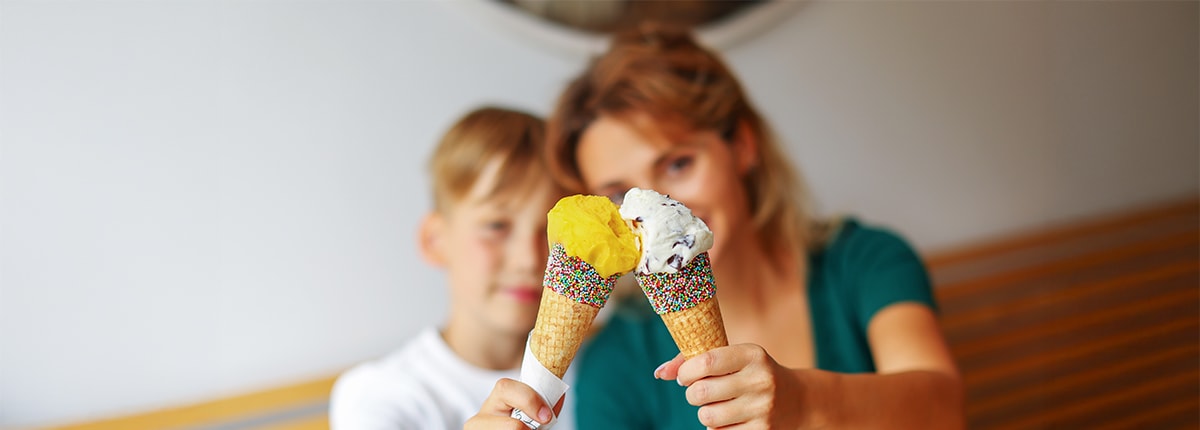 guests holding their ice cream cone while sitting on a bench