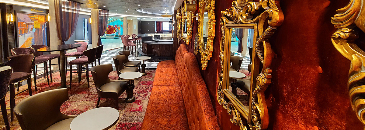 red velvet walls adorned with gold frames and mirrors at fortune teller bar