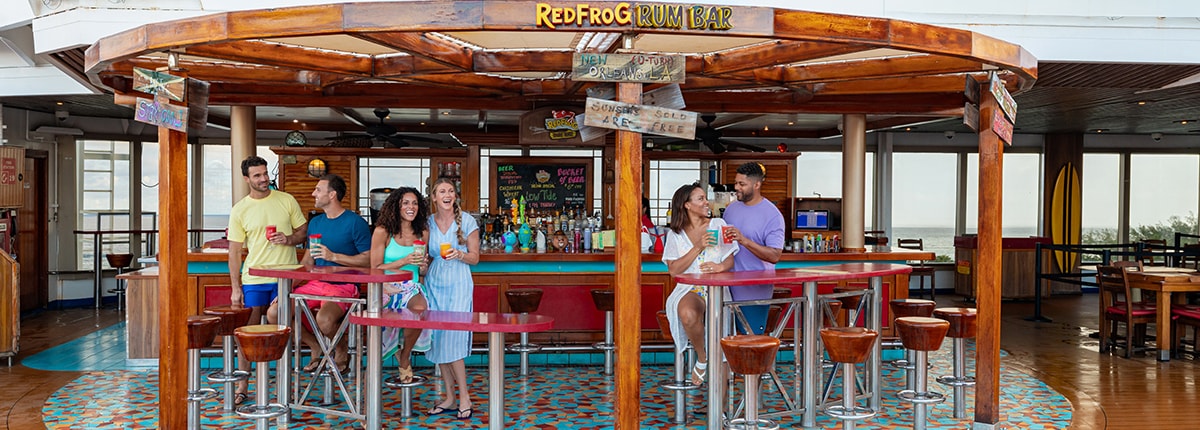 a group of friends enjoys drinks in front of the redfrog rum bar