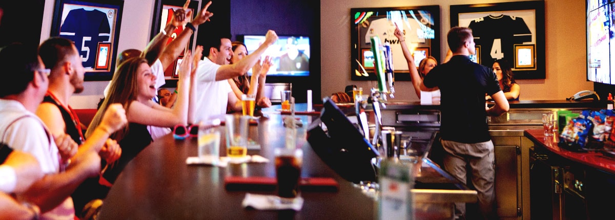 guests cheering at carnival skybox sports bar