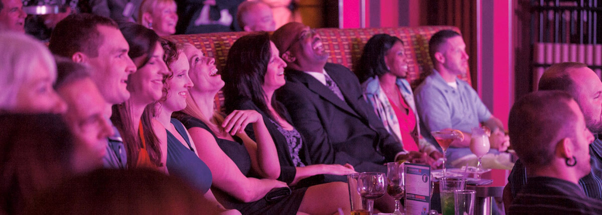 guest laughing during a punchliner comedy club show on a carnival cruise ship