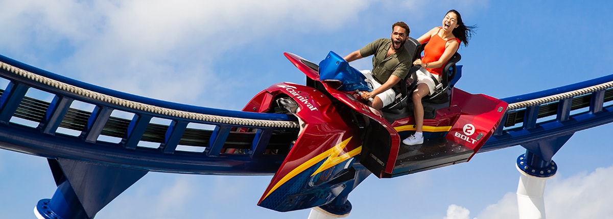 man and woman playfully scream while riding the bolt roller coaster aboard a carnival cruise ship