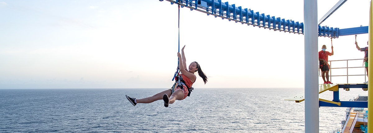 guest having fun during the zip line activity onboard a carnival cruise ship